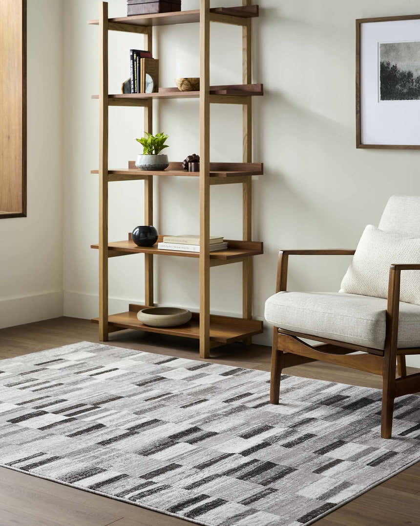 Living room scene with a Cherie Cream area rug, wood shelving unit, and mid-century modern chair. Roomscene-Rectangle