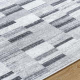 Close-up of the Cherie Cream Area Rug featuring a contemporary gray, light silver, and sage geometric pattern. Texture