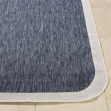 Close-up of Chetan Navy Outdoor Rug showing navy and cream colors and machine woven texture. Front