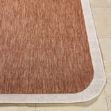 Close-up of Chetan Brown outdoor rug showing woven texture, brown and cream colors, and rounded corner. Front
