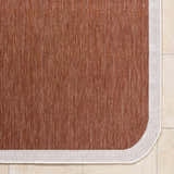 Close-up of the Chetan Brown Outdoor Rug. The rug has a woven texture and a cream border. Corner