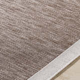 Close-up of the Chetan Dark Brown Area Rug showing the woven texture and cream border. Texture