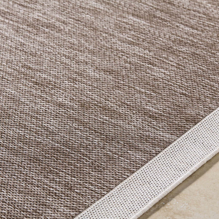 Close-up of the Chetan Dark Brown Area Rug showing the woven texture and cream border. Texture