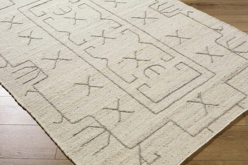 Close up of the beige, hand woven, wool Chanda Area Rug with a contemporary geometric pattern. Corner