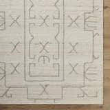 Close up of the beige Chanda Area Rug showing its hand woven texture and contemporary geometric pattern. Corner