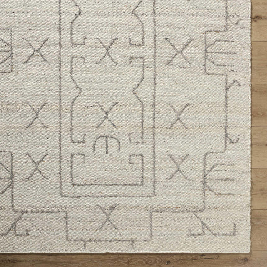 Close up of the beige Chanda Area Rug showing its hand woven texture and contemporary geometric pattern. Corner