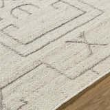 Close up of the beige wool Chanda Area Rug showing its hand woven texture and contemporary geometric pattern. Texture