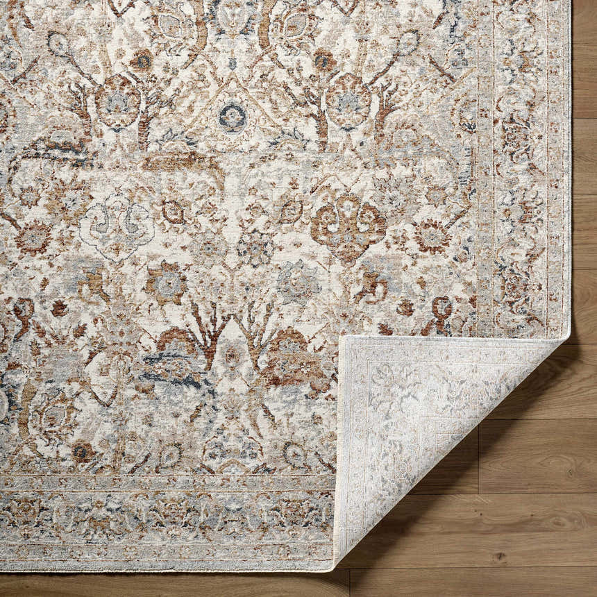 Close-up of the Chikao Cream Area Rug. Beige, cream, mustard, and blue traditional floral pattern. Machine woven polyester rug. Fold