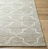 Close-up of the beige and gray Damawato Jute Carpet showing the hand woven texture and geometric pattern. Front