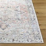 Close-up of the Aethwy Washable Area Rug. Farmhouse style rug in light silver, prairie dust, and silver gray on a wood floor. Front