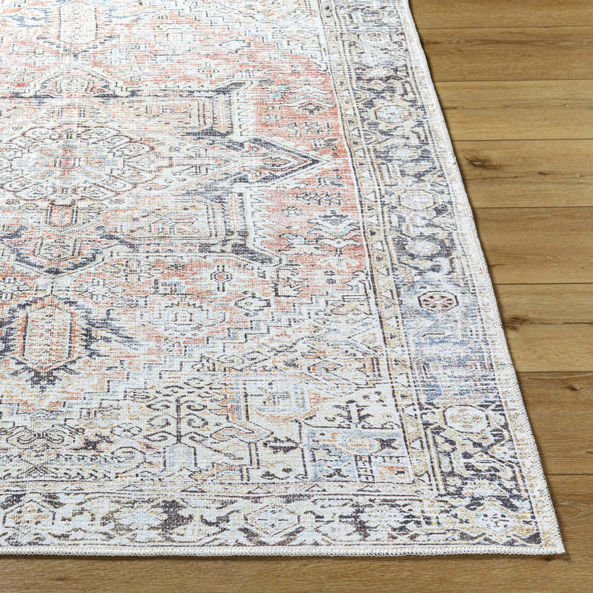 Close-up of the Aethwy Washable Area Rug. Farmhouse style rug in light silver, prairie dust, and silver gray on a wood floor. Front