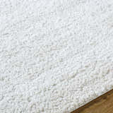Close up of the plush, white shag texture of the Arlind Area Rug. Texture