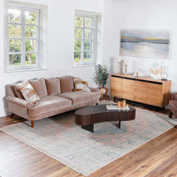 Living room scene with a camel sofa and the Adamstown handmade cotton-blend rug in peach, sage, and white. Roomscene-Rectangle