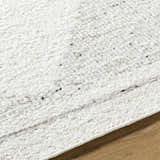 Close-up of the Ethara Ivory Charcoal rug showing its hand-woven texture and subtle global-inspired pattern. Texture