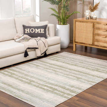 Living room scene with a light sofa and the Asmara Green Area Rug on a dark wood floor. Roomscene-Rectangle