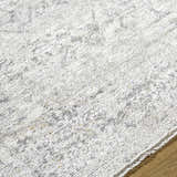 Close-up of the Alivia Area Rug, showing its ivory, charcoal, and gray traditional pattern and soft polyester texture. Texture