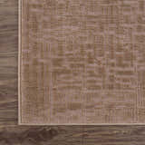 Close-up of the Leanna Light Brown Washable Area Rug. The rug has a subtle geometric pattern and a textured surface. Corner