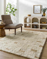Neutral living room with a beige chair, light wood console, and the Anusha Area Rug. Roomscene-Rectangle