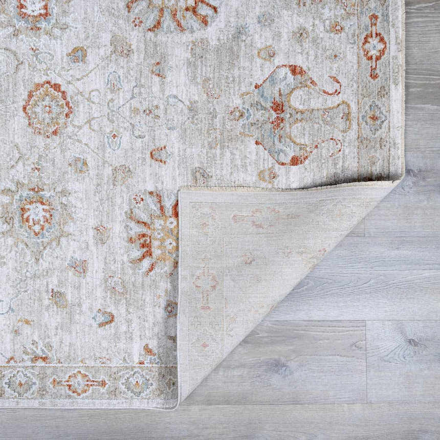 Close-up of Elimbah Thick Luxe Area Rug. Beige rug with brick red, charcoal, and light blue traditional floral pattern. Fold