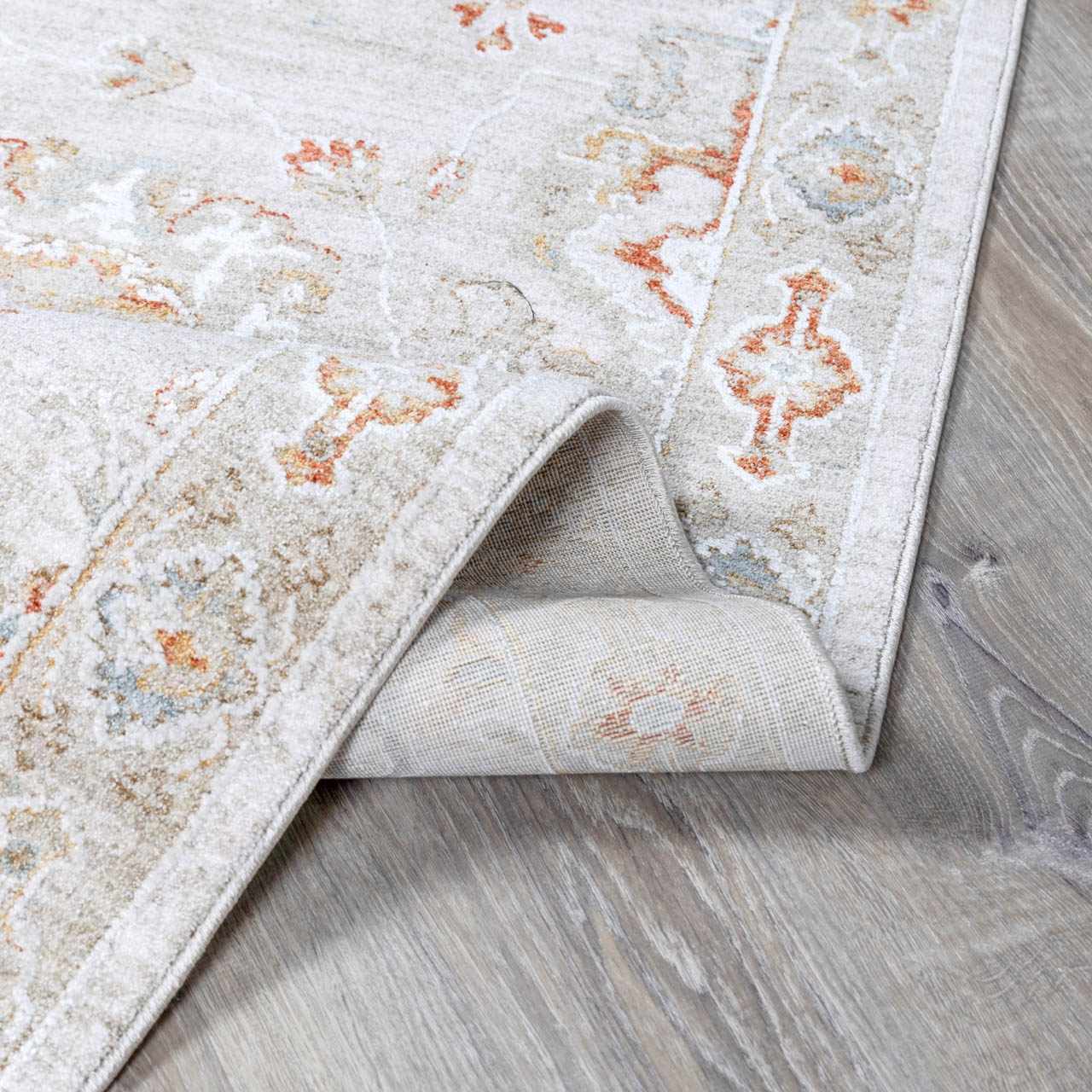 Close-up of the Elimbah Thick Luxe Area Rug showing beige, brick red, and charcoal colors with a traditional oriental pattern. Fold