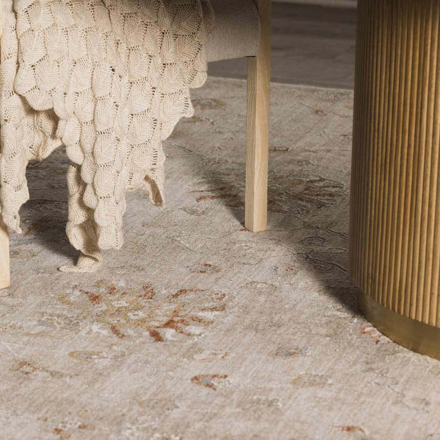 Close-up of the beige Elimbah Thick Luxe Area Rug with traditional floral pattern, styled with a wooden table and knit throw. Styleshot