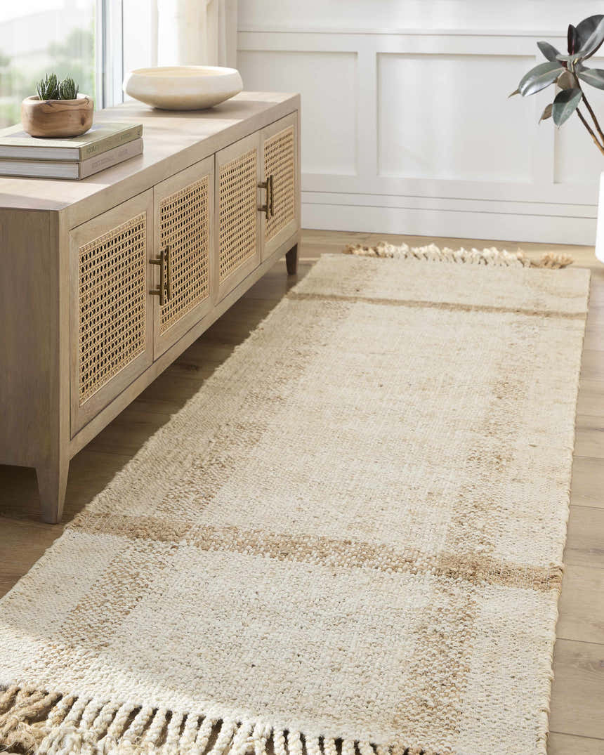 Entryway with a beige Errin Jute Area Rug runner, wood floors, and a light wood cabinet with decor. Roomscene-Runner