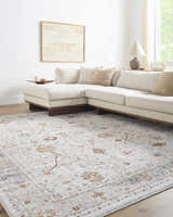 Living room with a Paatan Luxe Floral Oushaq Area Rug, cream sectional sofa, wood floors, and neutral decor. Roomscene-Rectangle