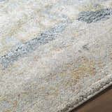 Close-up of the Alanna Thick Luxe Area Rug. Beige, gray, light gray, olive, pale blue, and teal hues create a contemporary design. Texture
