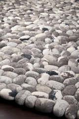Close up of the hand woven Fillmore Area Carpet. Wool rug features black, charcoal, cream, and gray tones. Styleshot