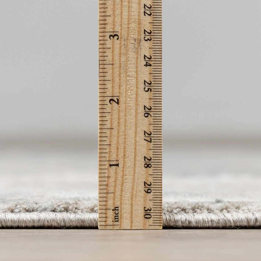 Close-up of the Fallin Gray Thick Luxe Abstract Striped Rug showing its plush pile height with a ruler for scale. Pile
