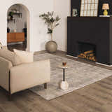 Living room scene with a Fallin Gray Thick Luxe Abstract Striped Rug, beige sofa, fireplace, and wood floors. Roomscene-Rectangle