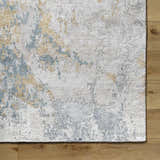 Close-up of the hand-knotted Follansbee Area Rug. Beige, charcoal, gray, and light sage abstract design. Viscose texture. Corner