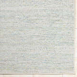 Close-up of the Alezae Ivory Area Rug showing its woven texture and ivory, light gray, and pale blue colors. Corner