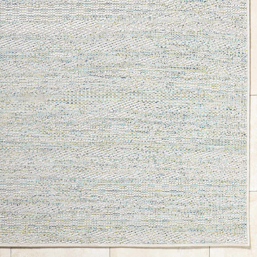 Close-up of the Alezae Ivory Area Rug showing its woven texture and ivory, light gray, and pale blue colors. Corner