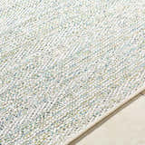 Close-up of the Alezae Ivory Area Rug. Woven texture in ivory, light gray, and pale blue. Farmhouse style. Texture