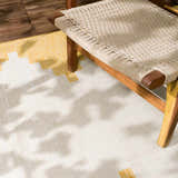 Close-up of the Djugun Yellow Outdoor Rug with geometric beige and yellow pattern, paired with a woven chair. Styleshot