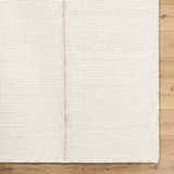 Close up of the neutral Xowi Global Modern wool rug showing hand woven texture and detail. Corner