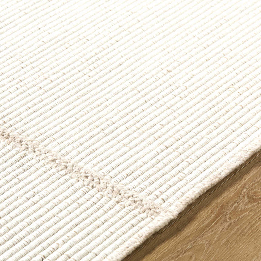 Close-up of the hand woven texture of the Xowi Global Modern Wool Area Rug in cream, on wood flooring. Texture