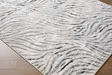 Close-up of the Arlene Area Rug. Contemporary style rug with black, cream, and gray wavy pattern. 60% Polyester. Corner