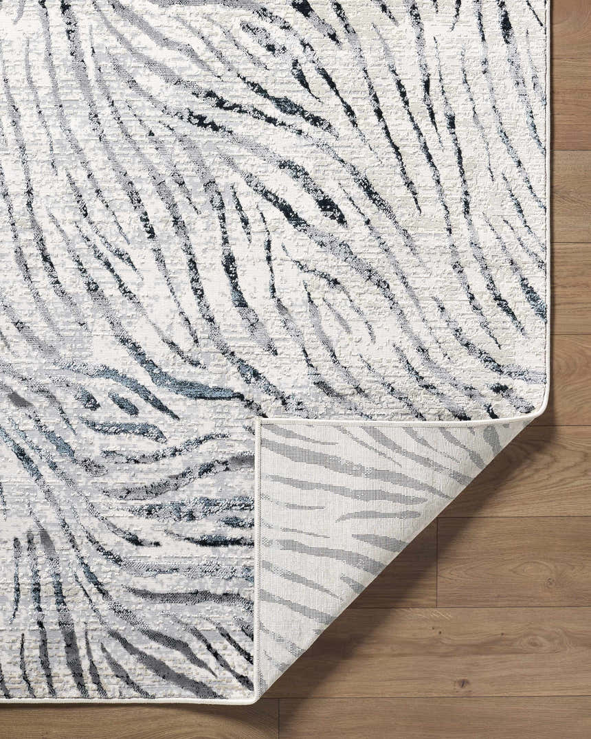 Close-up of the Arlene Area Rug showing its black, cream, and gray contemporary stripe pattern and machine-woven texture. Fold