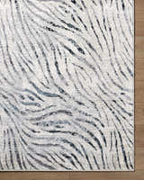 Close up of the Arlene Area Rug. Contemporary style rug in black, cream, gray, and light slate with a textured pattern. Corner