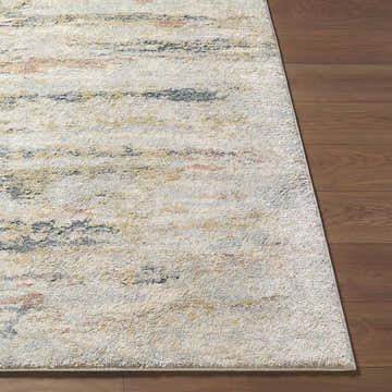 Close up of Attila Thick Luxe Area Rug showing beige, pink, gray, and teal colors on a wood floor. Front