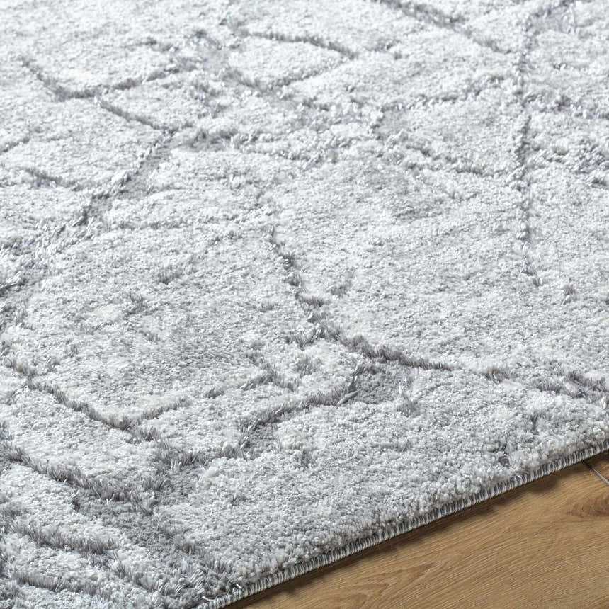 Close up of the Genkei Black Area Rug, showing its light gray, charcoal, and black geometric pattern and soft texture. Texture