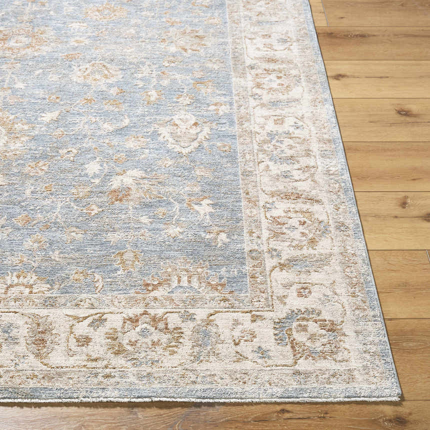 Close-up of Avivit Sage Area Rug. Traditional floral pattern in blue, cream, sage, and tan on a textured polyester rug. Front