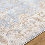 Close up of the Avivit Sage Area Rug. Farmhouse style rug with blue, cream, sage, and tan floral pattern. Texture
