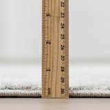 Close-up of the thick pile height of the Gilmanton Thick Luxe Boutique Rug, showing its texture and construction. Pile