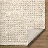 Close-up of the cream Armand Luxe Shag Rug showing its plush texture and machine-woven construction. Fold