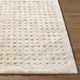 Close-up of the cream Armand Luxe Shag Rug showing its plush texture and subtle geometric pattern on a wood floor. Front