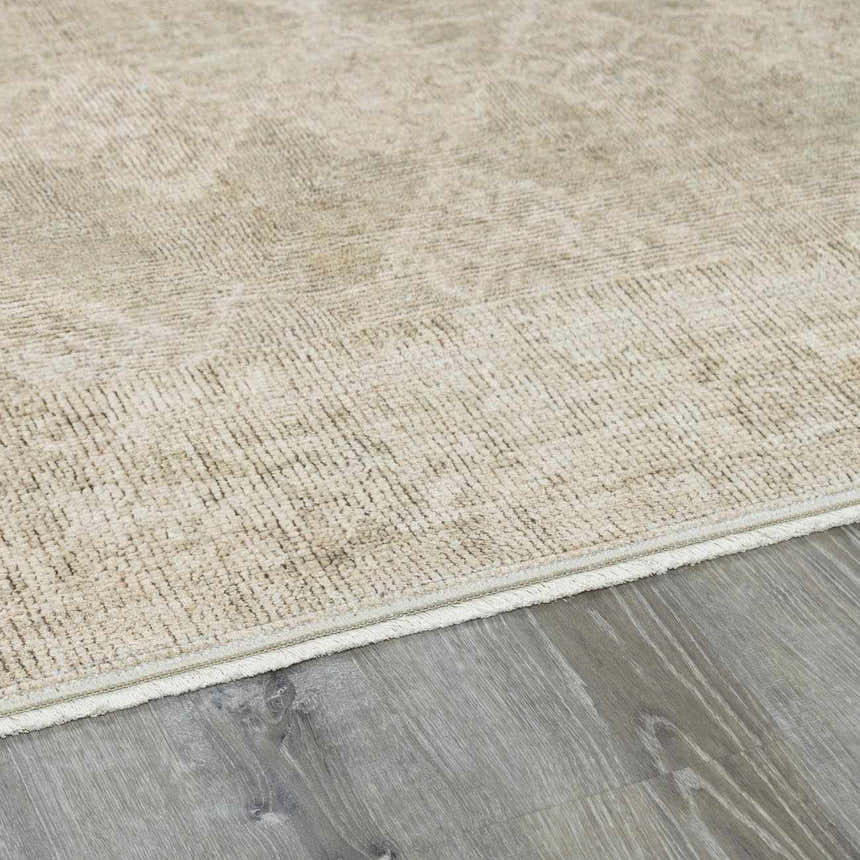 Close-up of the Fetscher IV Vintage Damask Area Rug. Light brown, olive, and peach tones with a subtle damask pattern. Corner