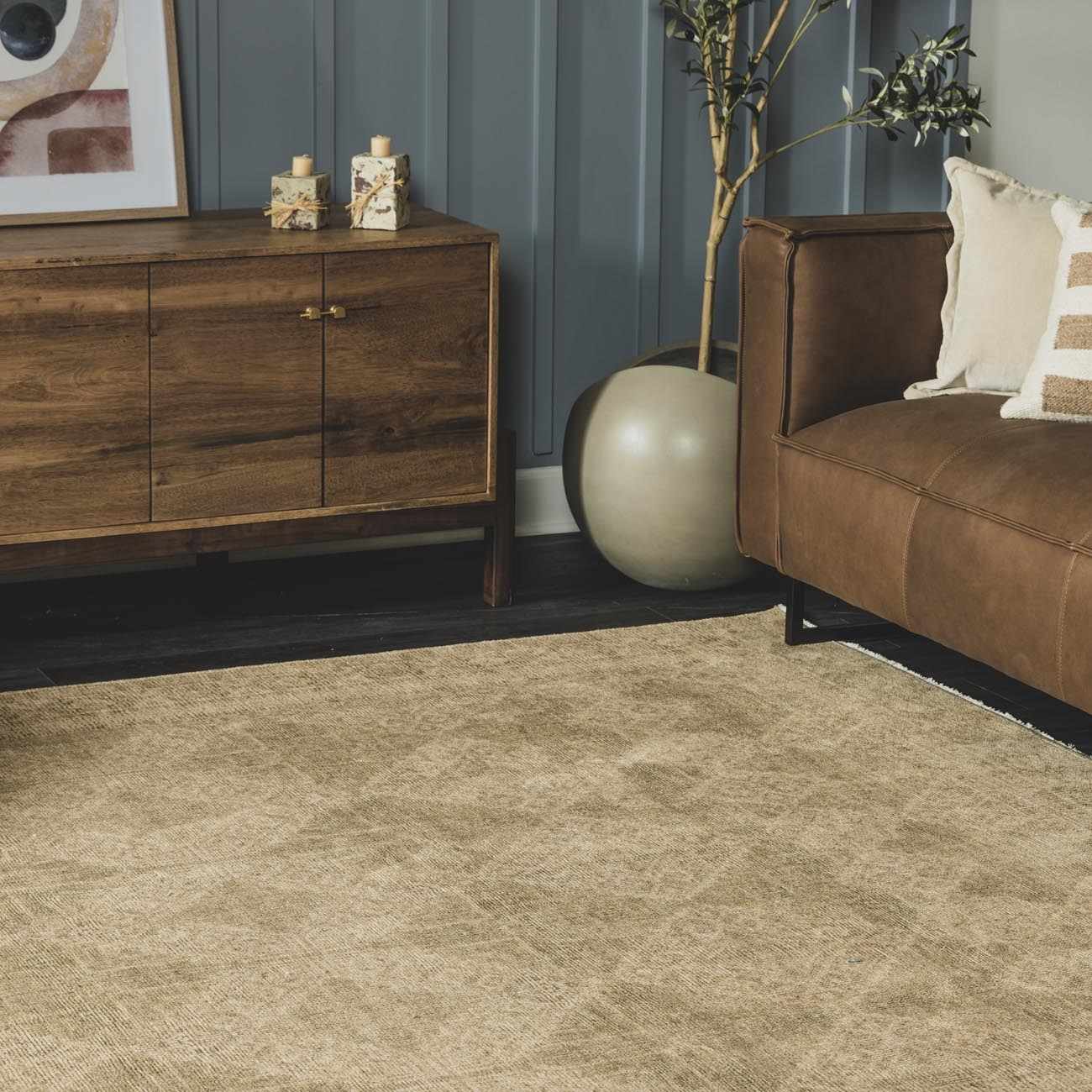 Living room scene with a light brown Fetscher IV Vintage Damask Area Rug, leather sofa, and wood cabinet. Roomscene-Rectangle